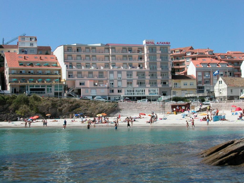 un groupe de personnes sur une plage près de l'eau dans l'établissement Hotel Altariño, à Portonovo