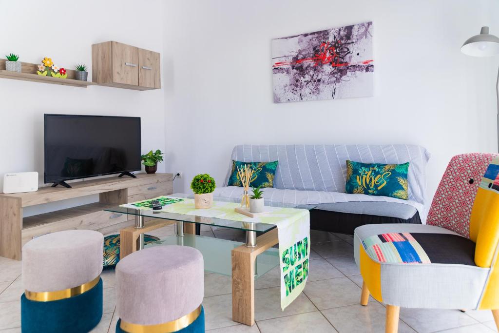een woonkamer met een bank, een tafel en stoelen bij Grigo apartments in Alexandroupoli