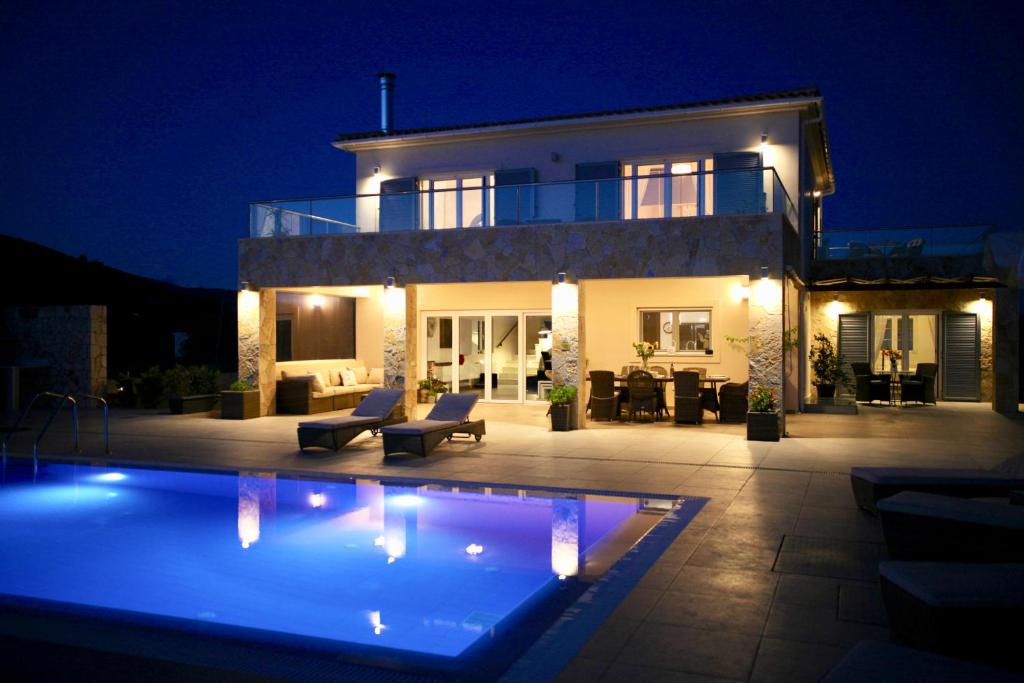 a house with a pool in front of it at night at Villa Darymine in Skala Kefalonias