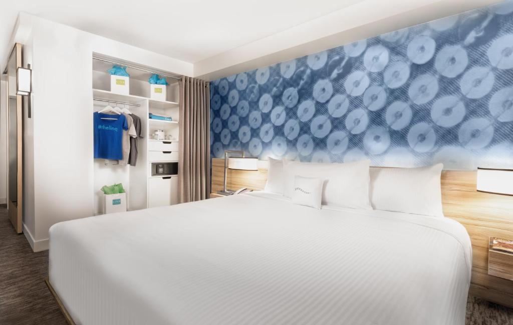 a bedroom with a white bed and a blue wall at The LINQ Hotel and Casino in Las Vegas