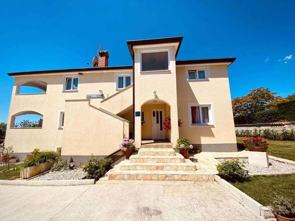 duży dom ze schodami przed nim w obiekcie Apartment in Sveti Lovrec - Istrien 27830 w mieście Sveti Lovreč Pazenatički