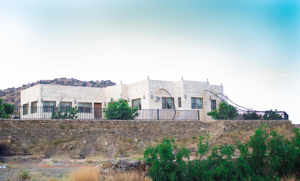 un edificio en la parte superior de una pared de piedra en فيلا الشفا الجبلية Al Shafa Villa en Al Shafa