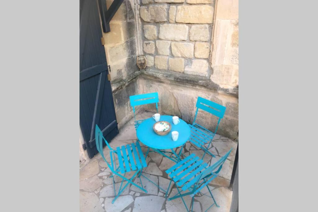 ein blauer Tisch und Stühle mit einer Uhr darauf in der Unterkunft Maison de charme in Montagnac