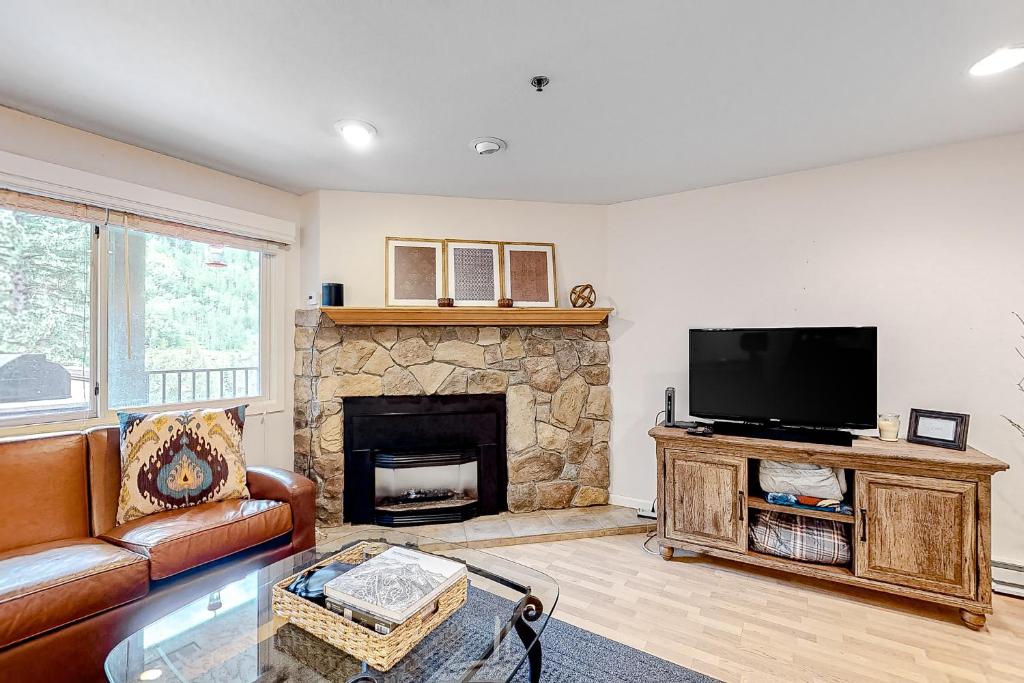 a living room with a fireplace and a television at Vail Dreams in Vail