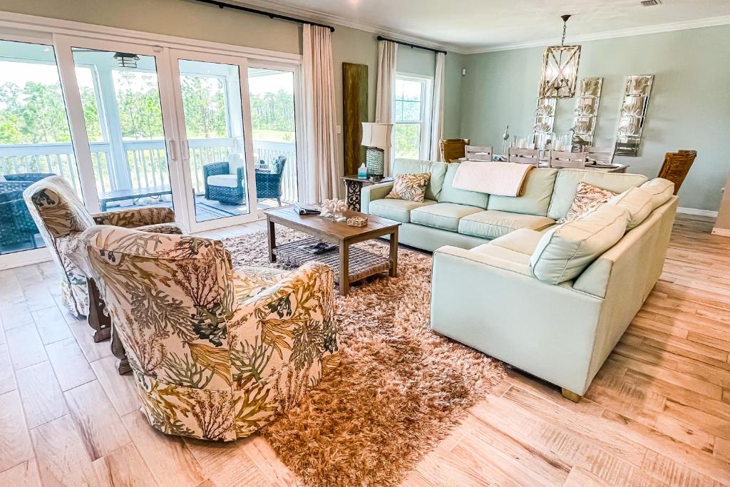 un soggiorno con divano, sedie e tavolo di Perdido Key Villa by the Sea a Perdido Key