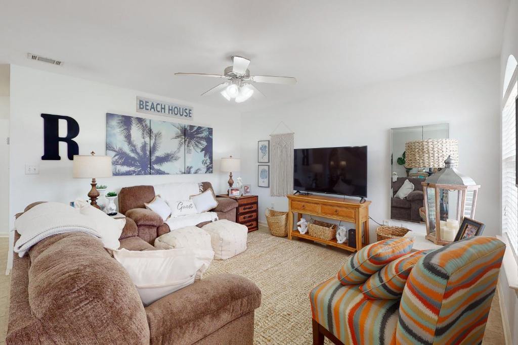 a living room with a couch and a tv at Paradise in the Palms in Mexico Beach