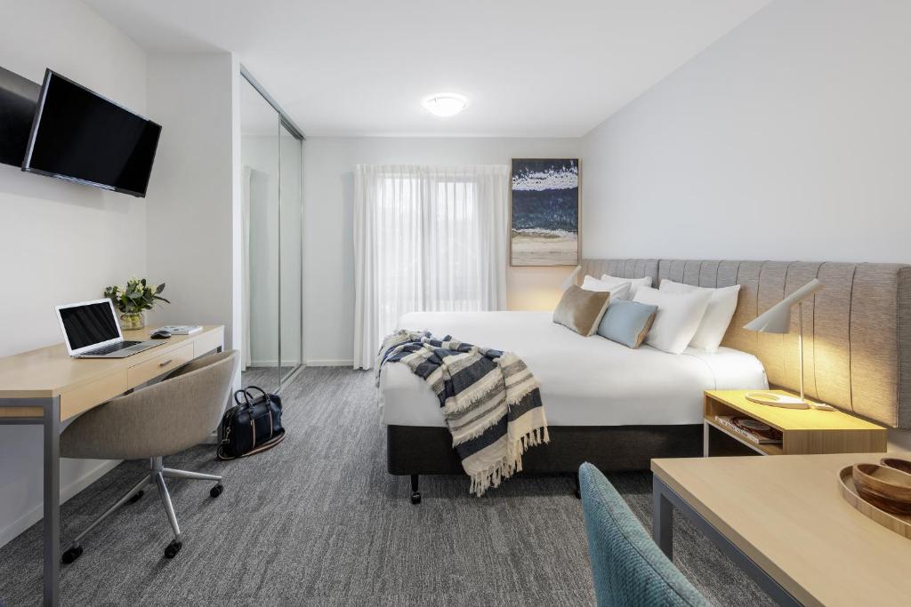 a hotel room with a bed and a desk at Quest Geelong in Geelong