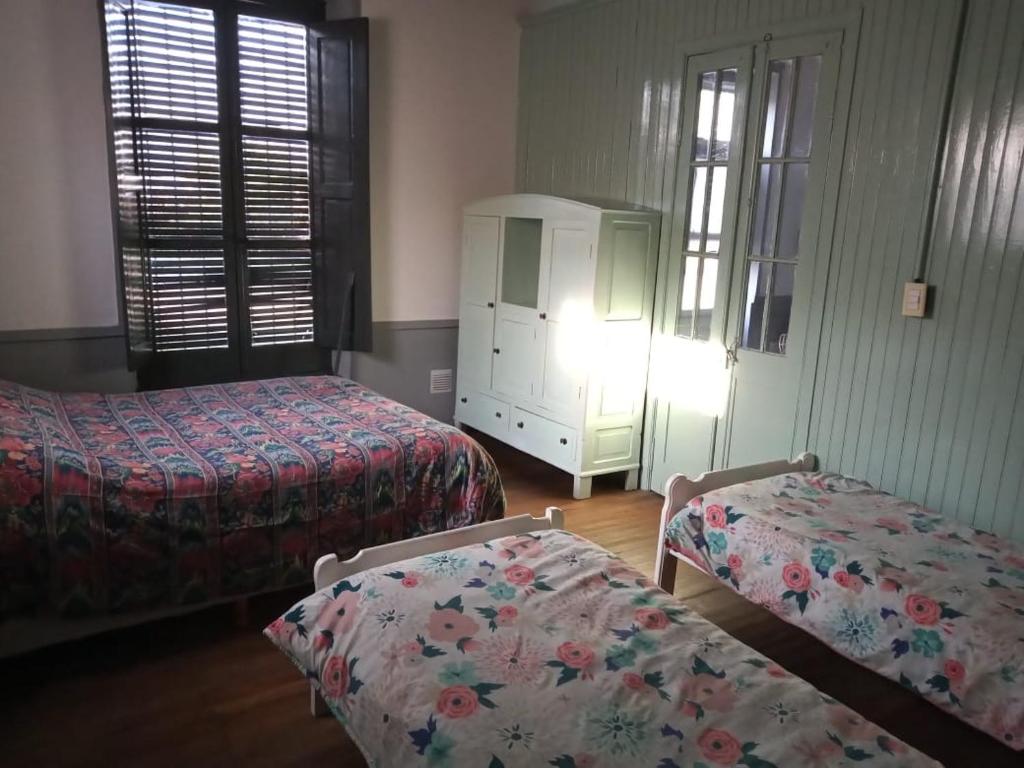 a hotel room with two beds and a dresser at La Casa del Molino in Ramallo