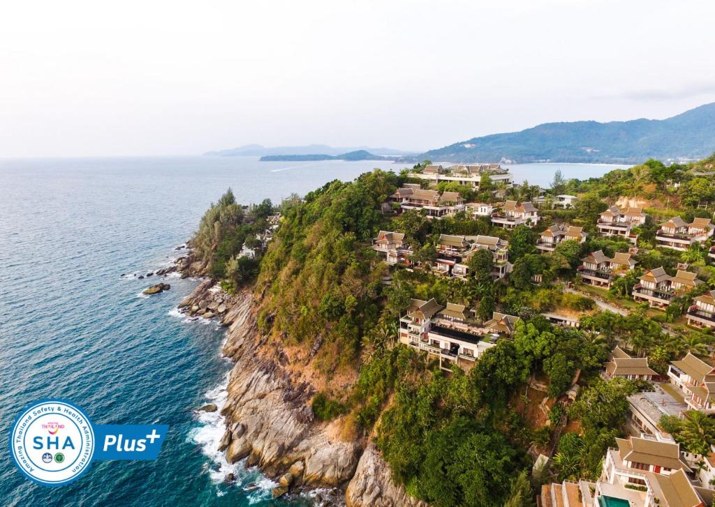 Ayara Kamala Resort & Spa - SHA Extra Plus في شاطئ كامالا: جزيرة في المحيط عليها بيوت