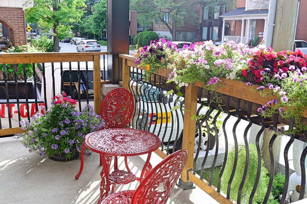 eine Terrasse mit 2 Stühlen, einem Tisch und Blumen in der Unterkunft Ottawa Downtown Executive Apartment Retreat with Private Balcony near Bank Street - Sleep Max 2 in Ottawa