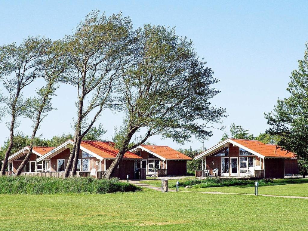 eine Gruppe von Häusern mit Bäumen auf einem Feld in der Unterkunft 6 person holiday home in Sk rb k in Skærbæk