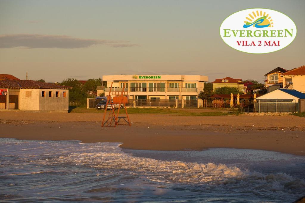 a building on the beach next to the ocean at Vila Evergreen 2 Mai in 2 Mai