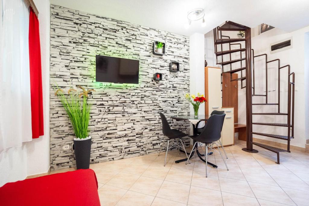 Apartment Kokolo في سبليت: غرفة بجدار حجري مع طاولة وكراسي