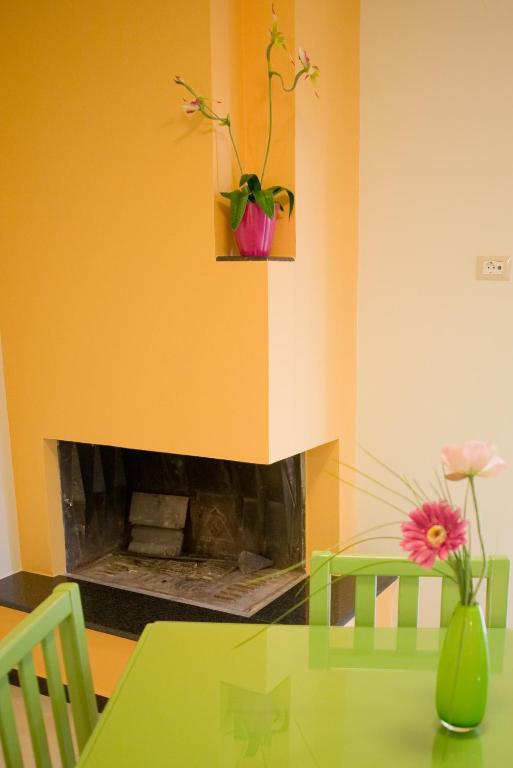 a dining room with a table and a fireplace at Amaryllis Hotel Apartments in Tolo