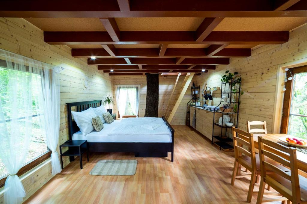 ein Schlafzimmer mit einem Bett in einem Holzzimmer in der Unterkunft Treehouse Zlatá Koruna in Zlatá Koruna