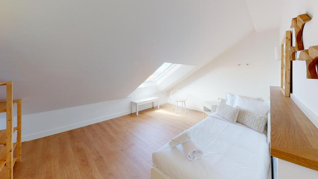 a white room with a bed and a table at Apartamentos La Casa El Palo in El Rompido