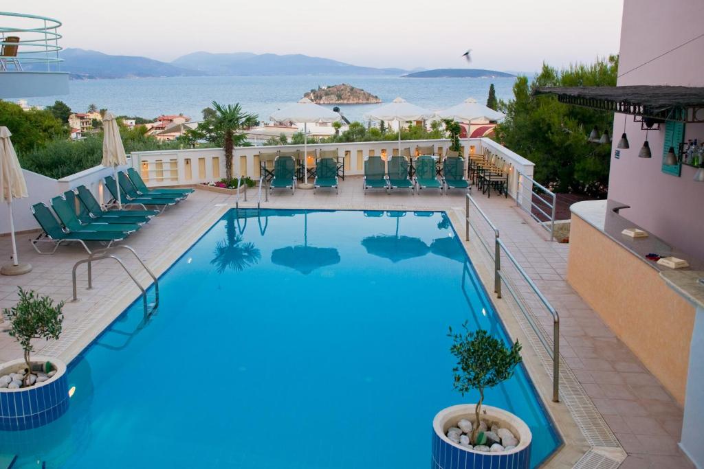 a pool at a hotel with a view of the ocean at Amaryllis Hotel Apartments in Tolo