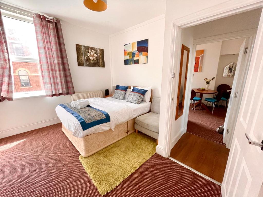 - une chambre avec un lit et un canapé dans l'établissement 4 bedroomed maisonette in City Centre, near Barbican & Seafront, à Plymouth