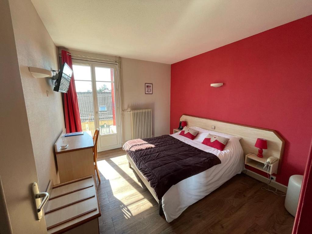 - une chambre dotée d'un lit avec un mur rouge dans l'établissement "Contact Hôtel" Le Saint Rémy - Chalon Sud, à Saint-Rémy