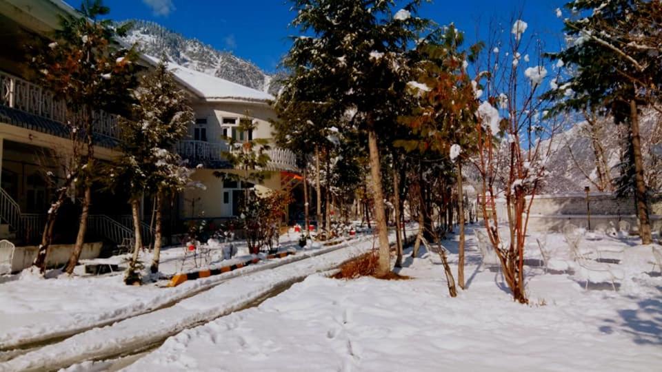 una calle cubierta de nieve frente a una casa en Sangam Hotel Kalam, en Kārandūkai