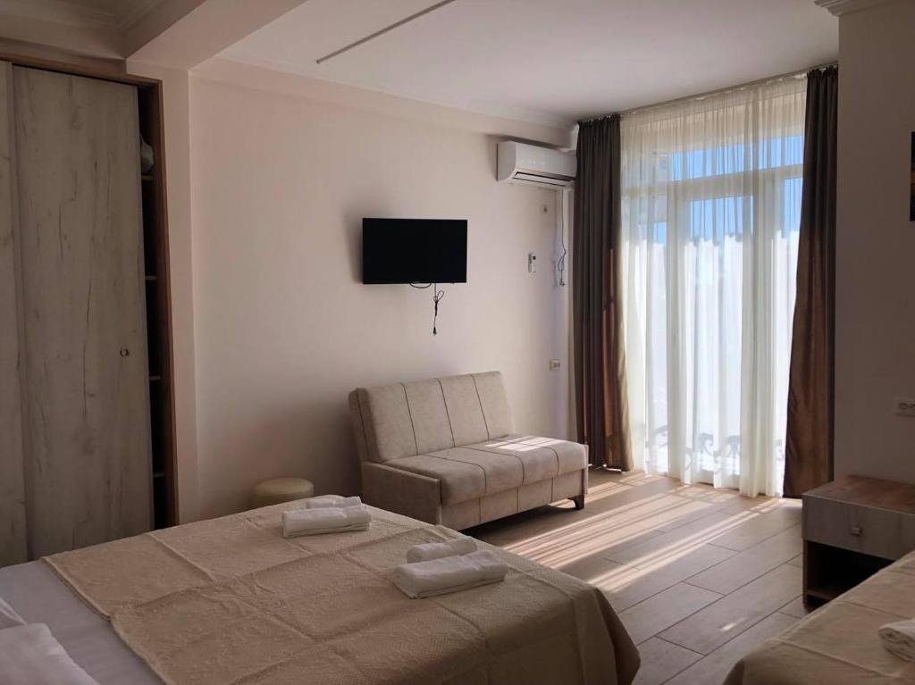 a bedroom with a bed and a chair and a television at Chaki Hotel in Ureki