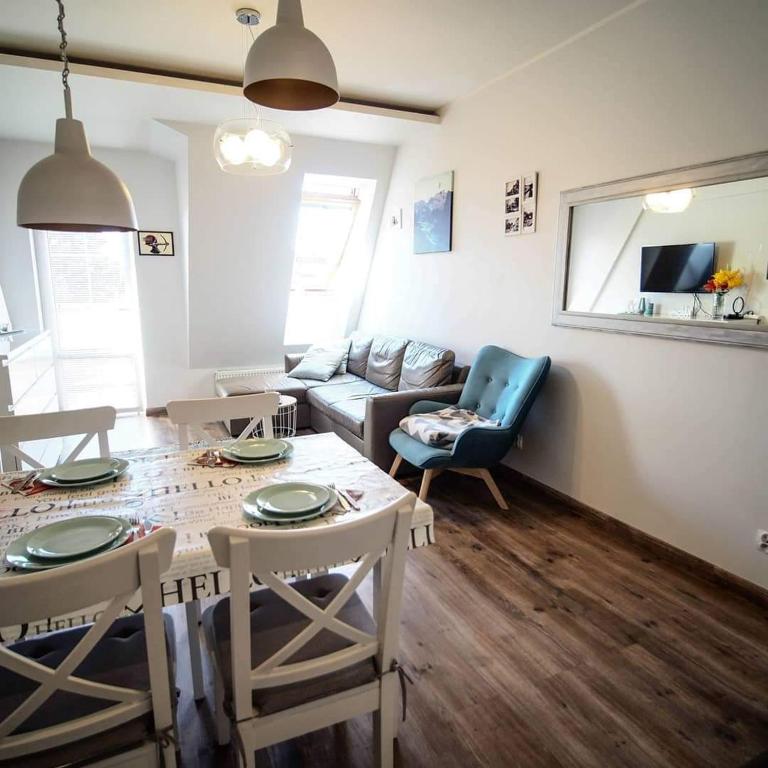 a living room with a table and chairs and a couch at Sweet Nest Apartment in Giżycko