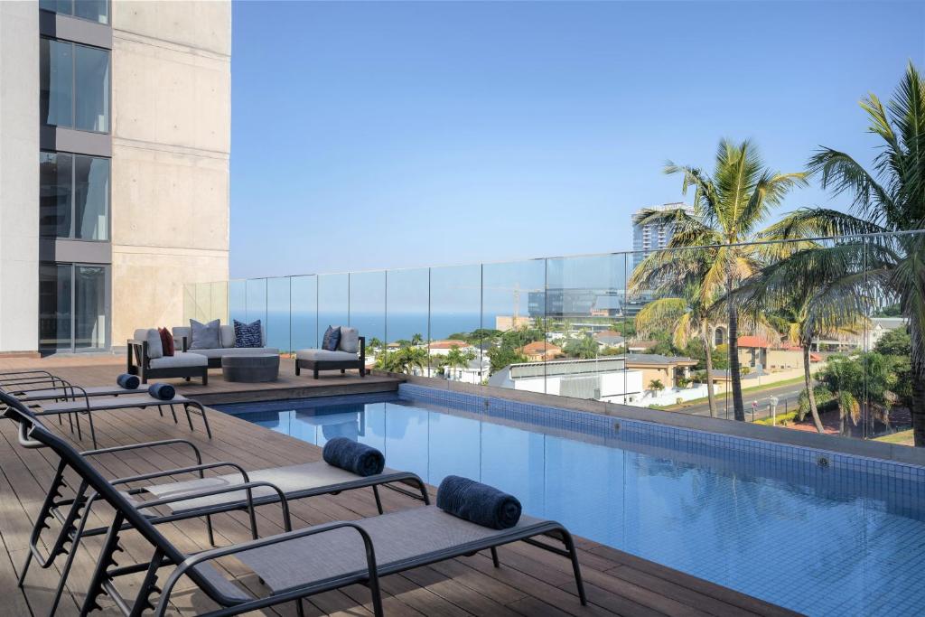 uma piscina do hotel com vista para o oceano em Premier Splendid Inn Umhlanga em Durban