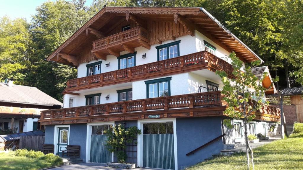 a large white house with a wooden roof at Ferienwohnung Appesbacher in St. Wolfgang