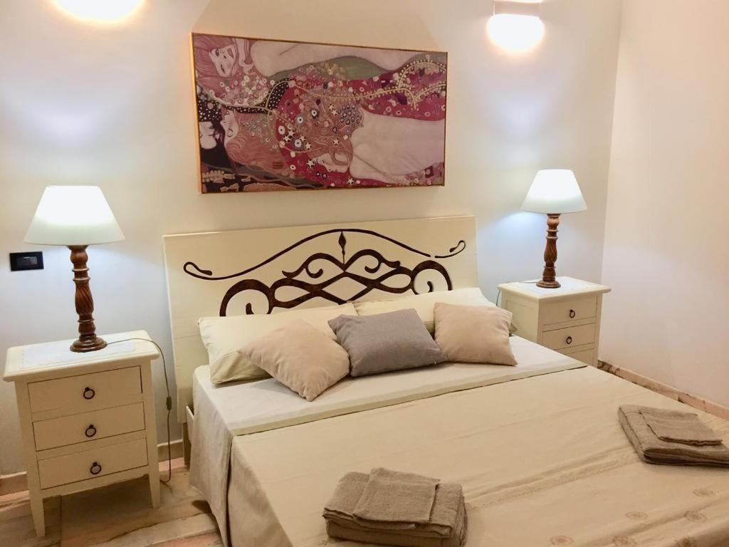 1 dormitorio con 1 cama grande y 2 mesitas de noche en Le Rose Suite Apartments, en Galatone