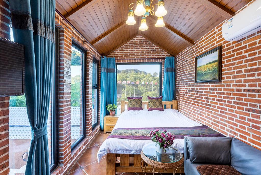 1 dormitorio con 1 cama en una pared de ladrillo en Beijing Mutianyu Great Wall Wangshanyuan Homestay, en Huairou