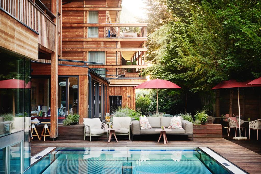 eine Terrasse mit einem Pool vor einem Gebäude in der Unterkunft Small Luxury Hotel of the World - DasPosthotel in Zell am Ziller