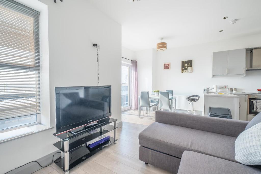 a living room with a couch and a flat screen tv at Portrush Marine Apartments flat1 in Portrush
