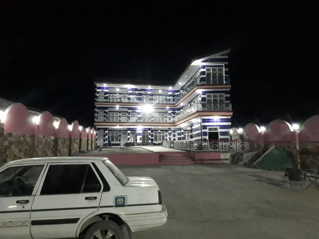 un coche blanco estacionado frente a un edificio por la noche en Calm kalam Hotel, en Kārandūkai