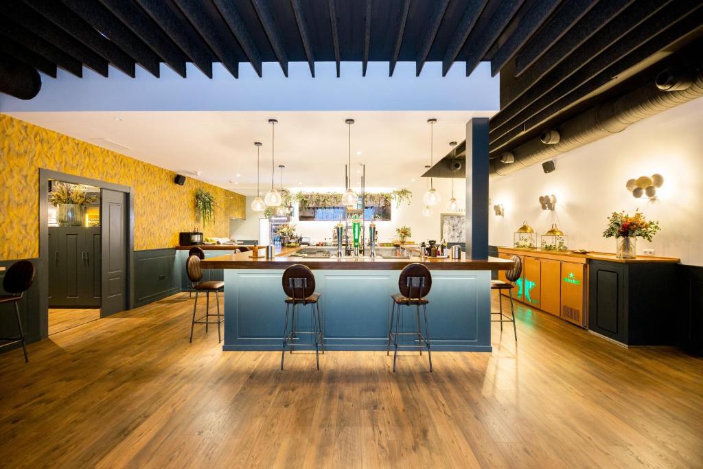 a large kitchen with a blue island with bar stools at HOTEL IBERUM in Illescas