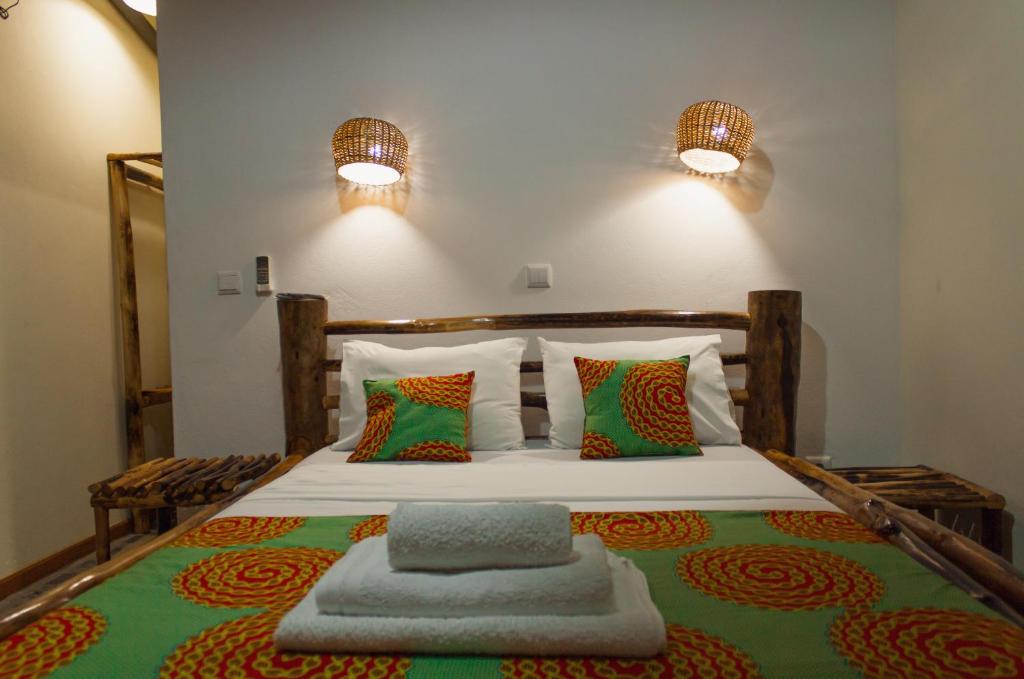 een slaapkamer met een bed met twee lampjes aan de muur bij Residêncial Tamarindos in M. Peixe