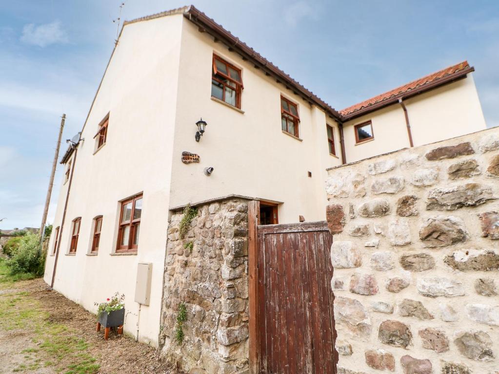 ein altes Steingebäude mit einer Holztür in der Unterkunft Gromit Cottage in Ripon