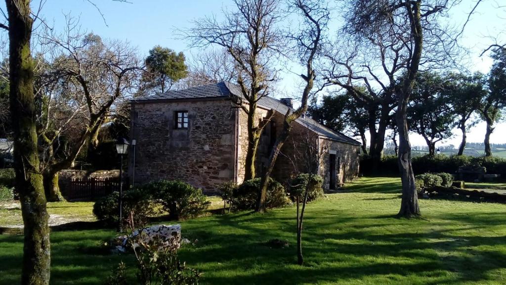 una vecchia casa in pietra in mezzo a un cortile di Rodeo Da Casa a O Reto 