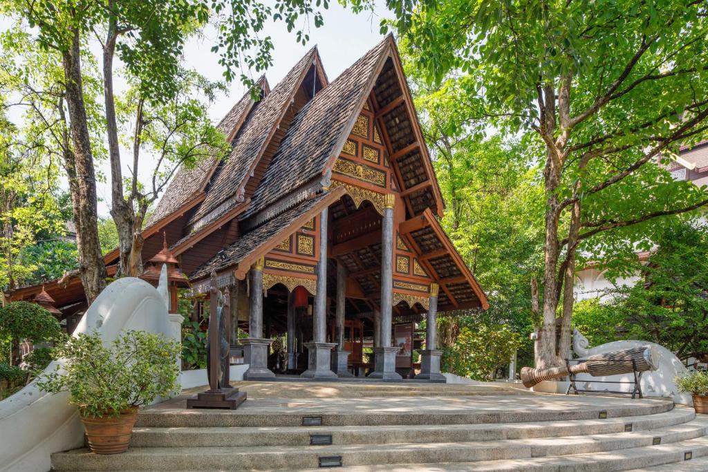 a temple in a park with stairs at Khum Phaya Resort & Spa Boutique Collection in Chiang Mai
