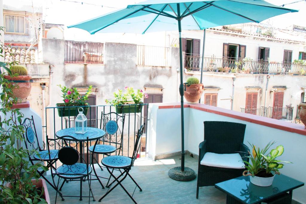 d'une terrasse avec des chaises et un parasol sur le balcon. dans l'établissement DAI MORI, à Palerme