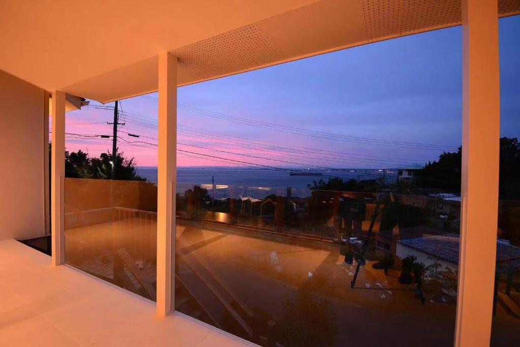 una ventana de un edificio con vistas a la puesta de sol en Wellis Villa HANARE en Awaji