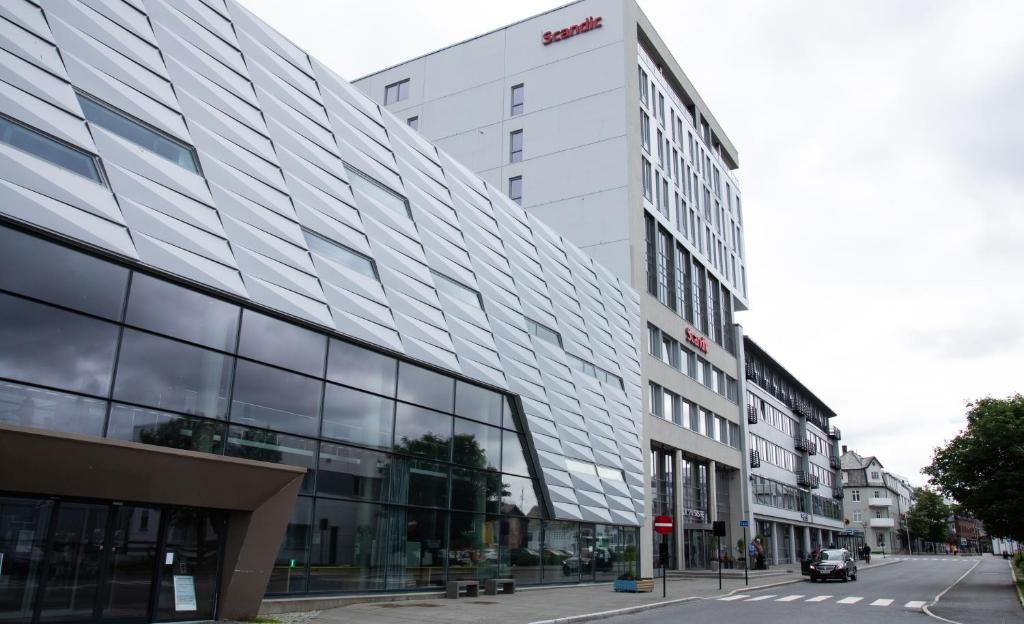 een hoog wit gebouw in een stadsstraat bij Scandic Syv Søstre in Sandnessjøen