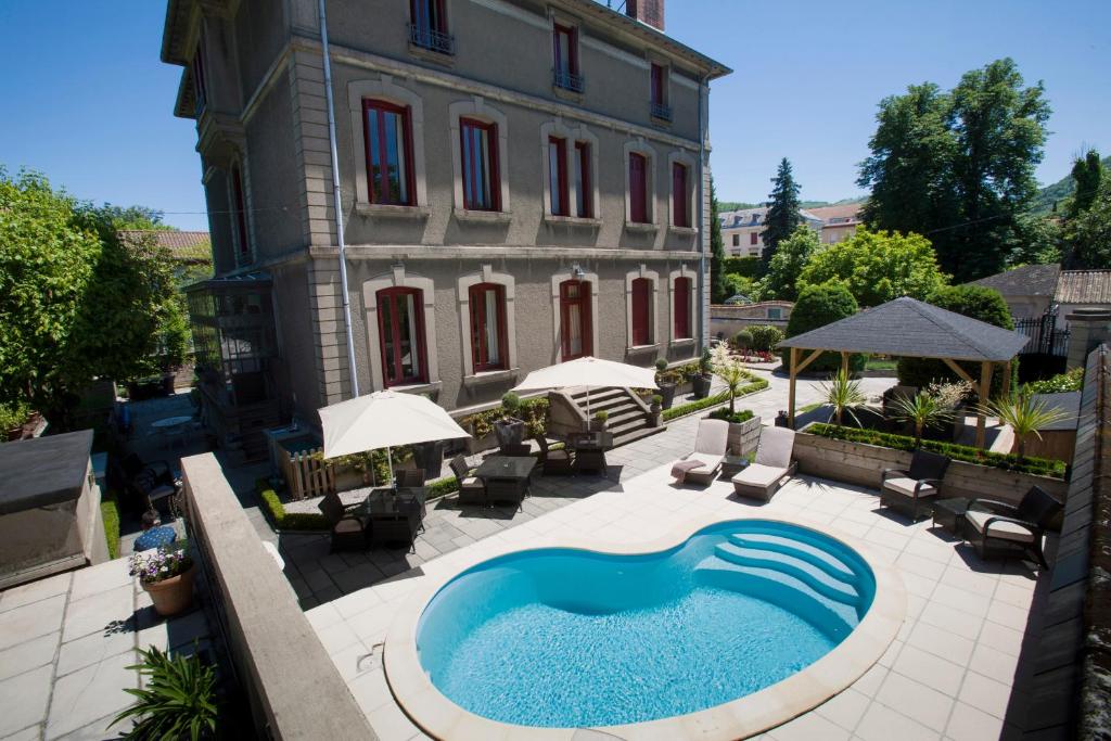 una piscina al aire libre frente a un edificio en La Villa de Mazamet, en Mazamet