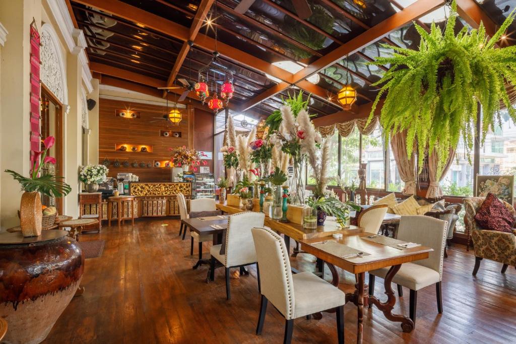 a restaurant with tables and chairs and plants at Khum Phaya Resort & Spa Boutique Collection in Chiang Mai