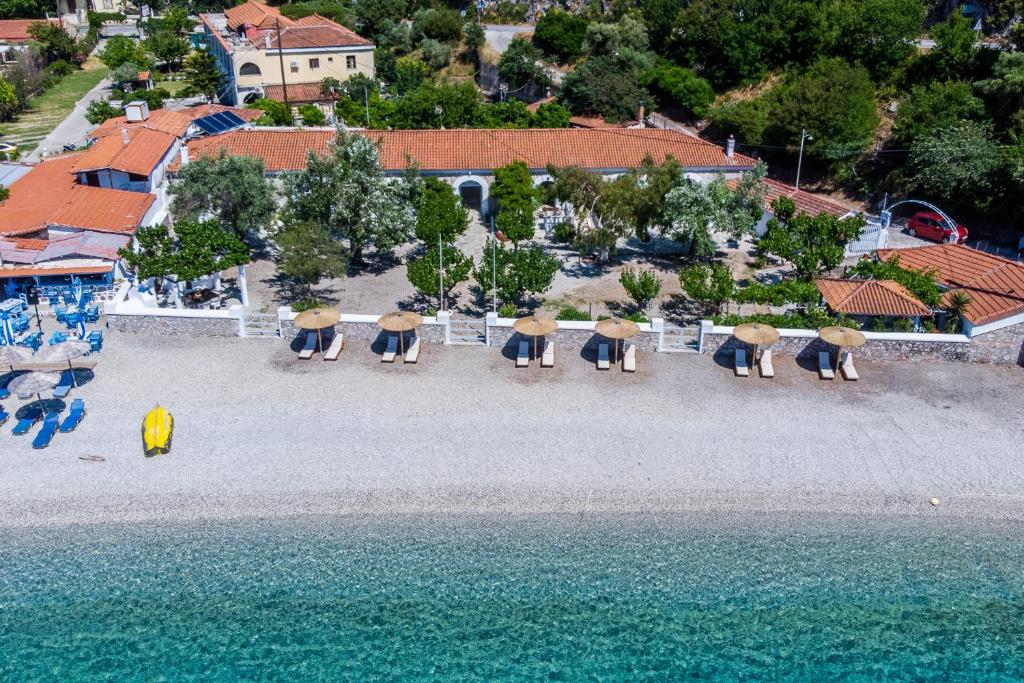 una vista aérea de una playa con sillas y sombrillas en PSARIANOS BEACHFRONT APARTMENTS, en Panormos Skopelos
