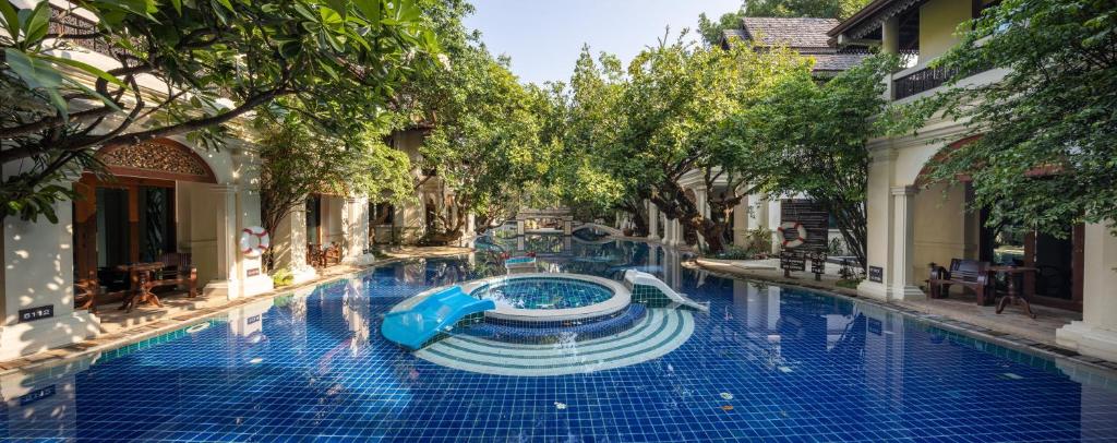 a swimming pool with a slide in the middle at Khum Phaya Resort & Spa Boutique Collection in Chiang Mai