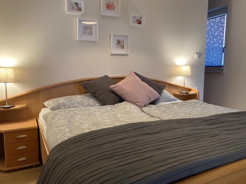 um quarto com uma cama com duas almofadas em Ferienwohnung am Hühnerberg em Buchbrunn