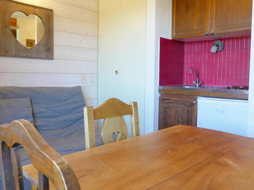 a kitchen with a wooden table and a kitchen with a sink at Studio Méribel, 1 pièce, 3 personnes - FR-1-182-43 in Méribel