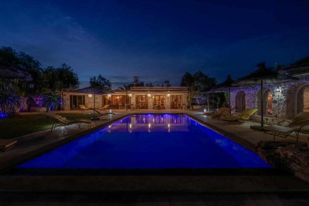 a swimming pool in front of a house at night at Absolu Beldi Essaouira in Essaouira