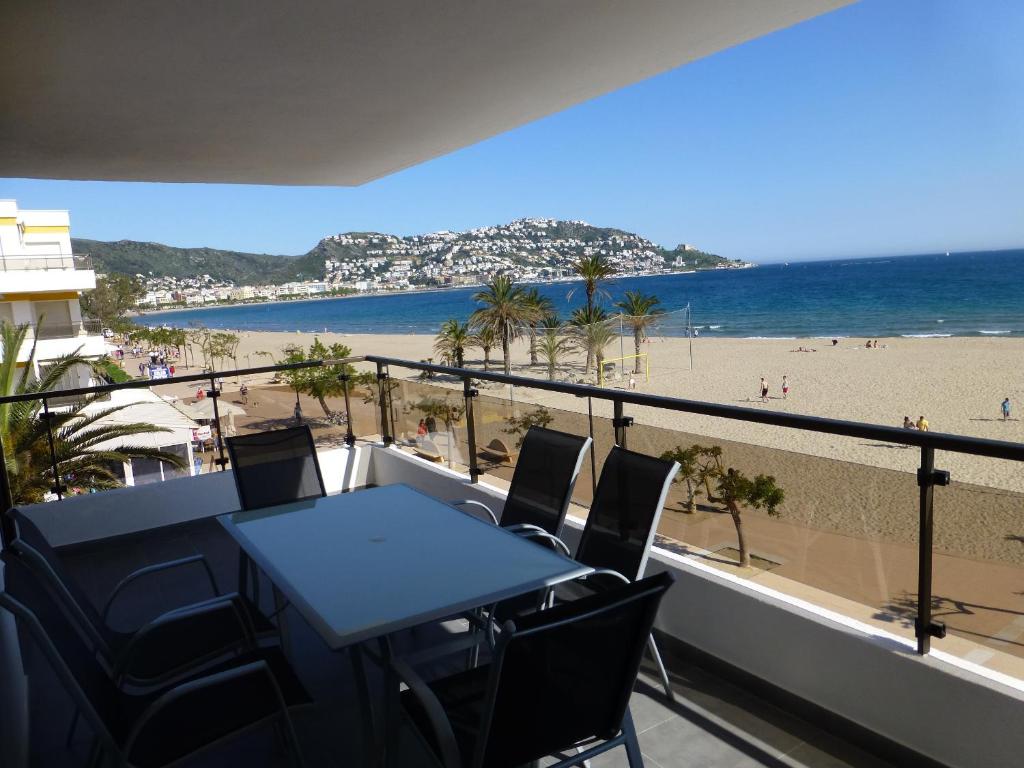 balcón con mesa y sillas y playa en InmoSantos Oasis A5, en Roses