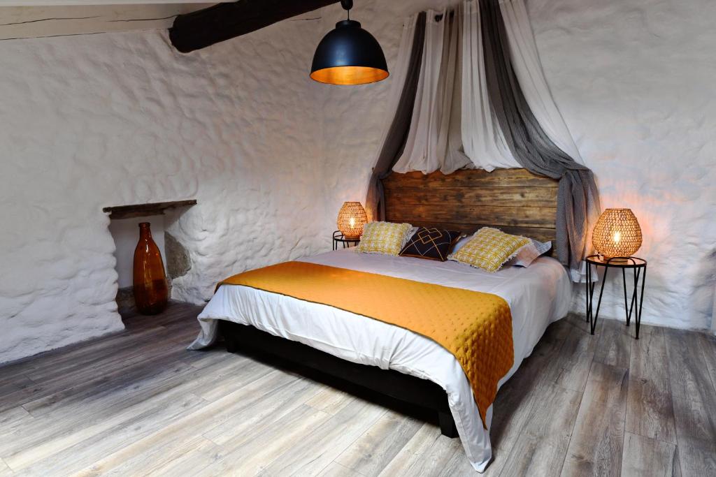 a bedroom with a bed and two tables and two lamps at Le Bruit de l'Eau (Chambre Cosy) in Labeaume